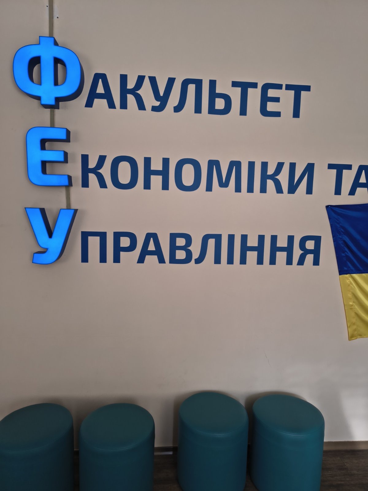 Великі контрасні літери із світловими індикаторами, що інформують відвідувача про факультет, який знаходеться в поточному блоці